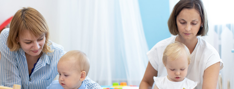 Deux assistantes maternelle s'occupant d'enfants en bas âge